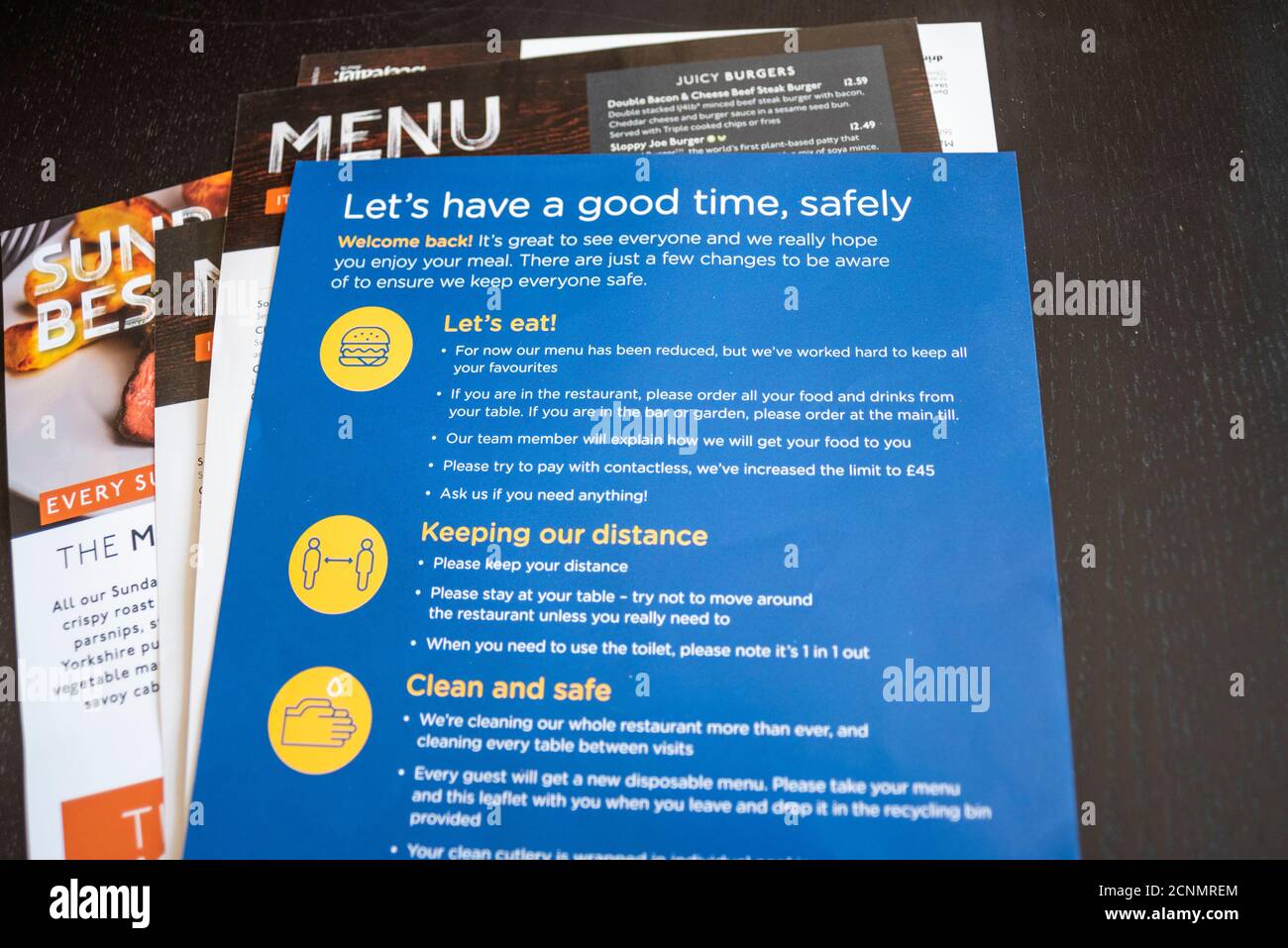 COVID 19 restaurant safety precautions at table. Hospitality industry welcome back, with single use, disposable menu and instructions. Welcome back Stock Photo