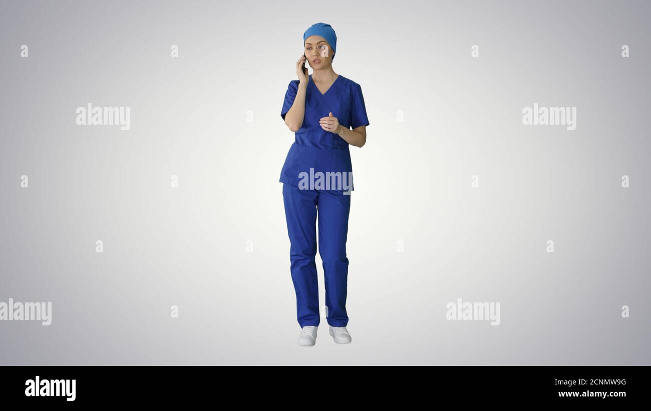 Serious female doctor talking on the phone on gradient backgroun Stock Photo