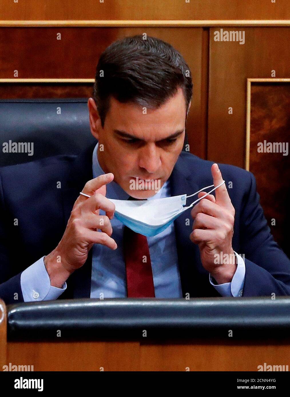 Spanish Prime Minister Pedro Sanchez puts his protective mask on during a plenary session amid the coronavirus disease (COVID-19) outbreak, at the Parliament in Madrid, Spain, May 20, 2020. Ballesteros/Pool via REUTERS Stock Photo