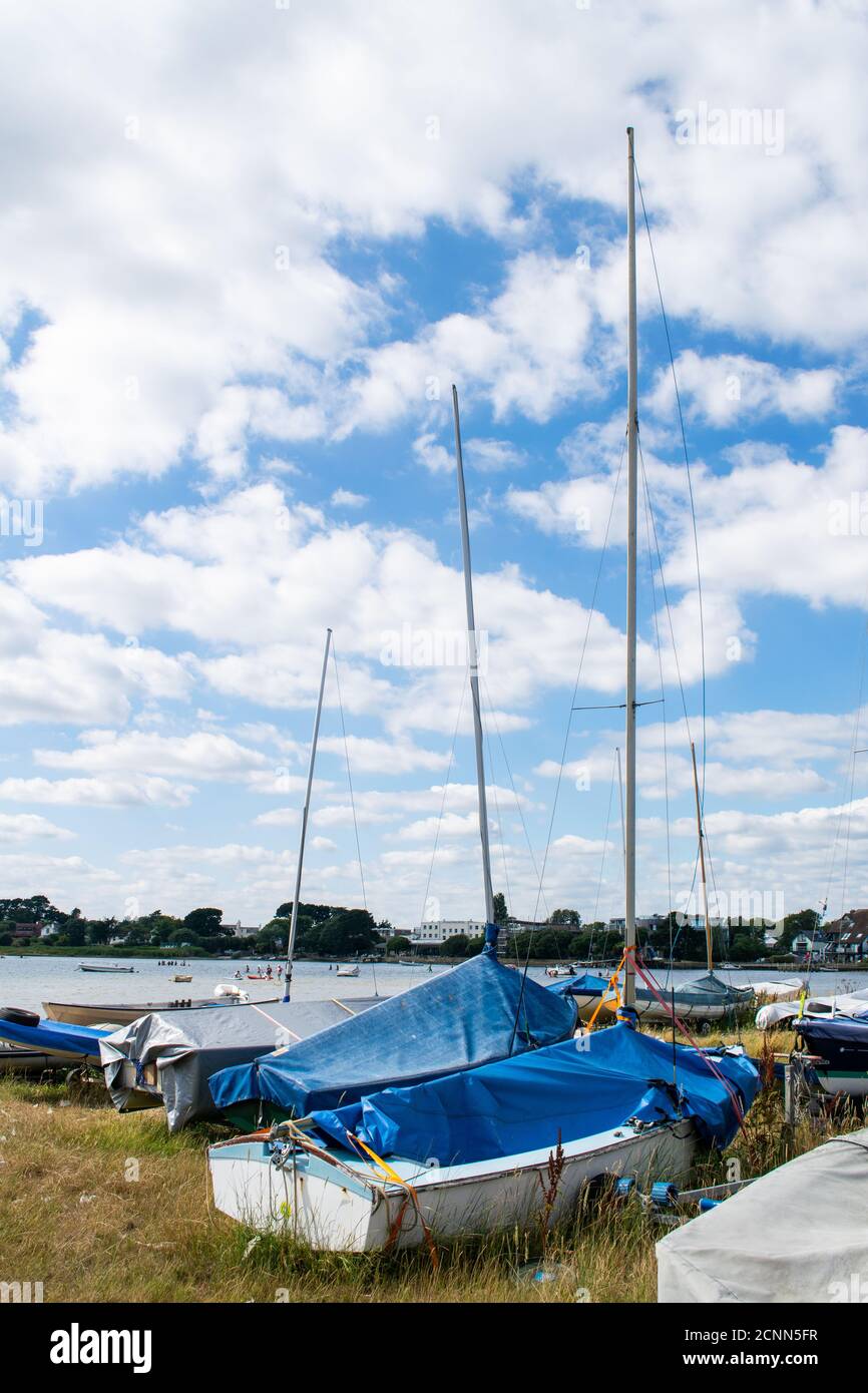 Small sailing or fishing boats on land with masts and covers on in