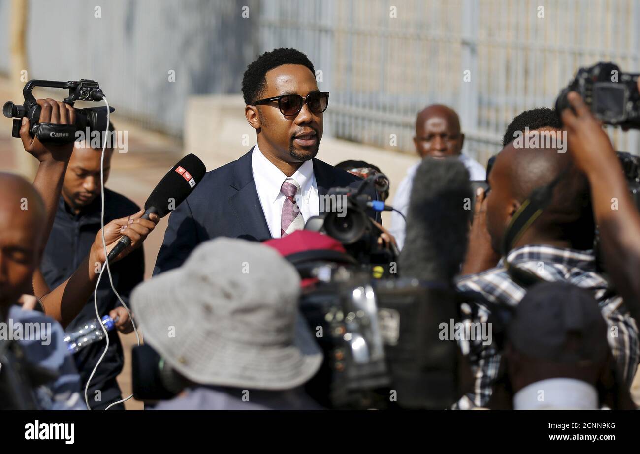Ndaba Mandela, grandson of late former South African president Nelson Mandela, is surrounded by members of the media as he leaves the Johannesburg court, August 25, 2015. The Mandela family, including Ndaba, arrived at Johannesburg's magistrate court on Tuesday for the bail hearing of one of Nelson Mandela's grandsons. A grandson of Nelson Mandela accused of raping a 15-year old girl was granted a 7,000 rand ($537.57) bail on Tuesday after spending more about a week in jail. The 24-year old grandson, who cannot be named because he is yet to plead to the charge, is accused of raping a 15-year o Stock Photo