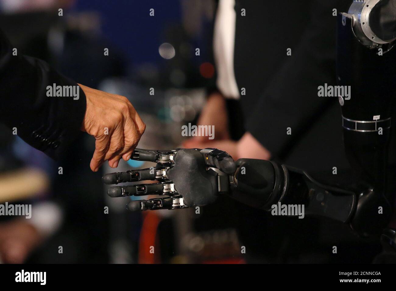 U.S. President Barack Obama touches a robotic arm operated by Nathan Copeland, a quadriplegic brain implant patient who can experience the sensation of touch and control a remote robotic arm with his brain during a tour of the innovation projects at the White House Frontiers conference in Pittsburgh, U.S. October 13, 2016. REUTERS/Carlos Barria Stock Photo