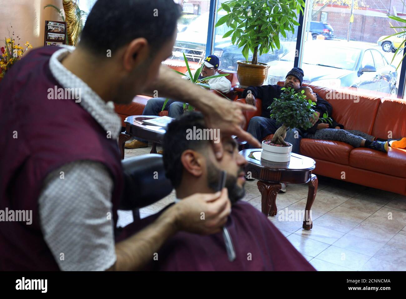 A father and son rest while awaiting their turn at Sinbad's Hair Salon in  Dearborn, Michigan, ., on November 12, 2016. REUTERS/Brittany Greeson  Stock Photo - Alamy