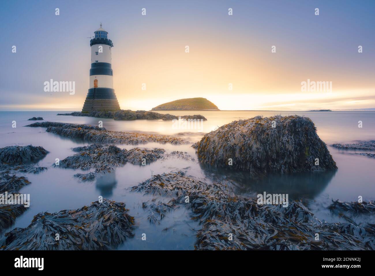 Penmon Lighthouse on coastal rocks, Anglesey, Wales, UK Stock Photo