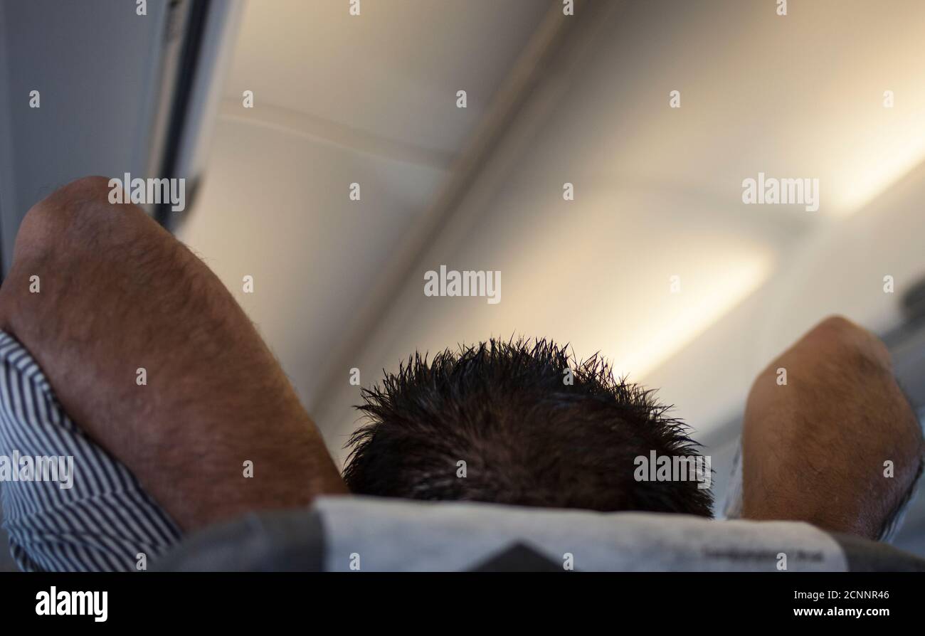 Travel scene - passenger relaxing in airplane. Stock Photo
