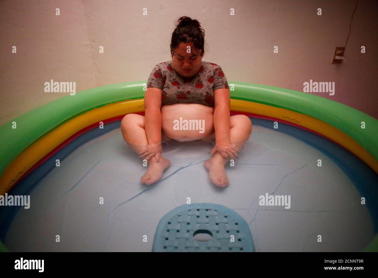 Karla Lopez Rangel, 24, who is pregnant, sits in an inflatable birthing pool as she experiences contractions at her home, where she plans to give birth, during the coronavirus disease (COVID-19) outbreak, in Xochimilco, Mexico City, Mexico, May 24, 2020. REUTERS/Gustavo Graf     SEARCH 'COVID-19 MEXICO BIRTH' FOR THIS STORY. SEARCH 'WIDER IMAGE' FOR ALL STORIES. Stock Photo