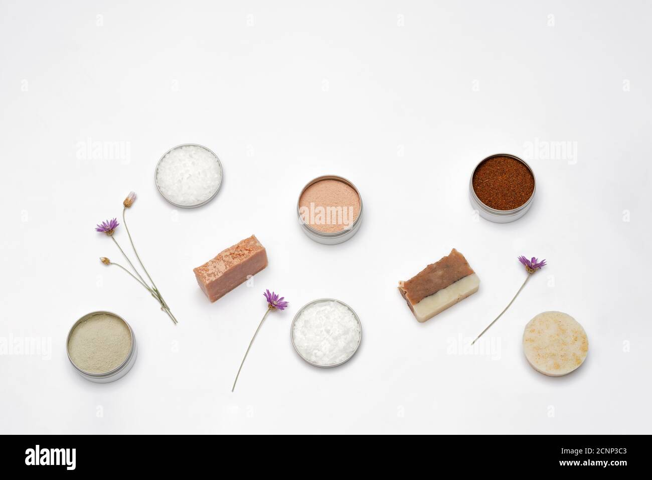 Ingredients for the production of cosmetics on a white background. Clays, wax, herbal powders, dried flowers, raspberry ketone. Natural cosmetics concept. Stock Photo