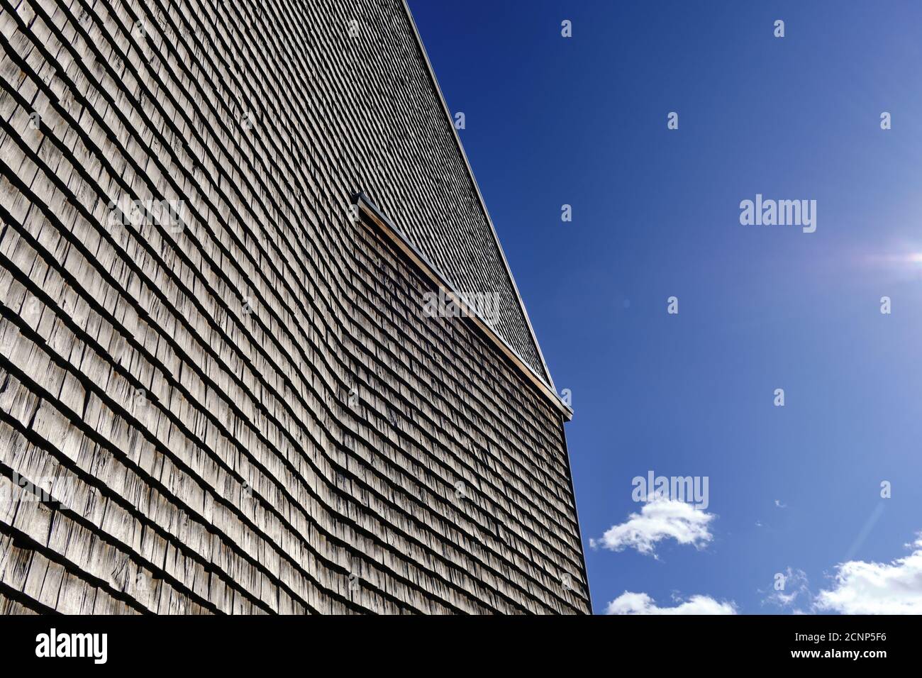 The facade of a modern wooden building on the blue sky background ...