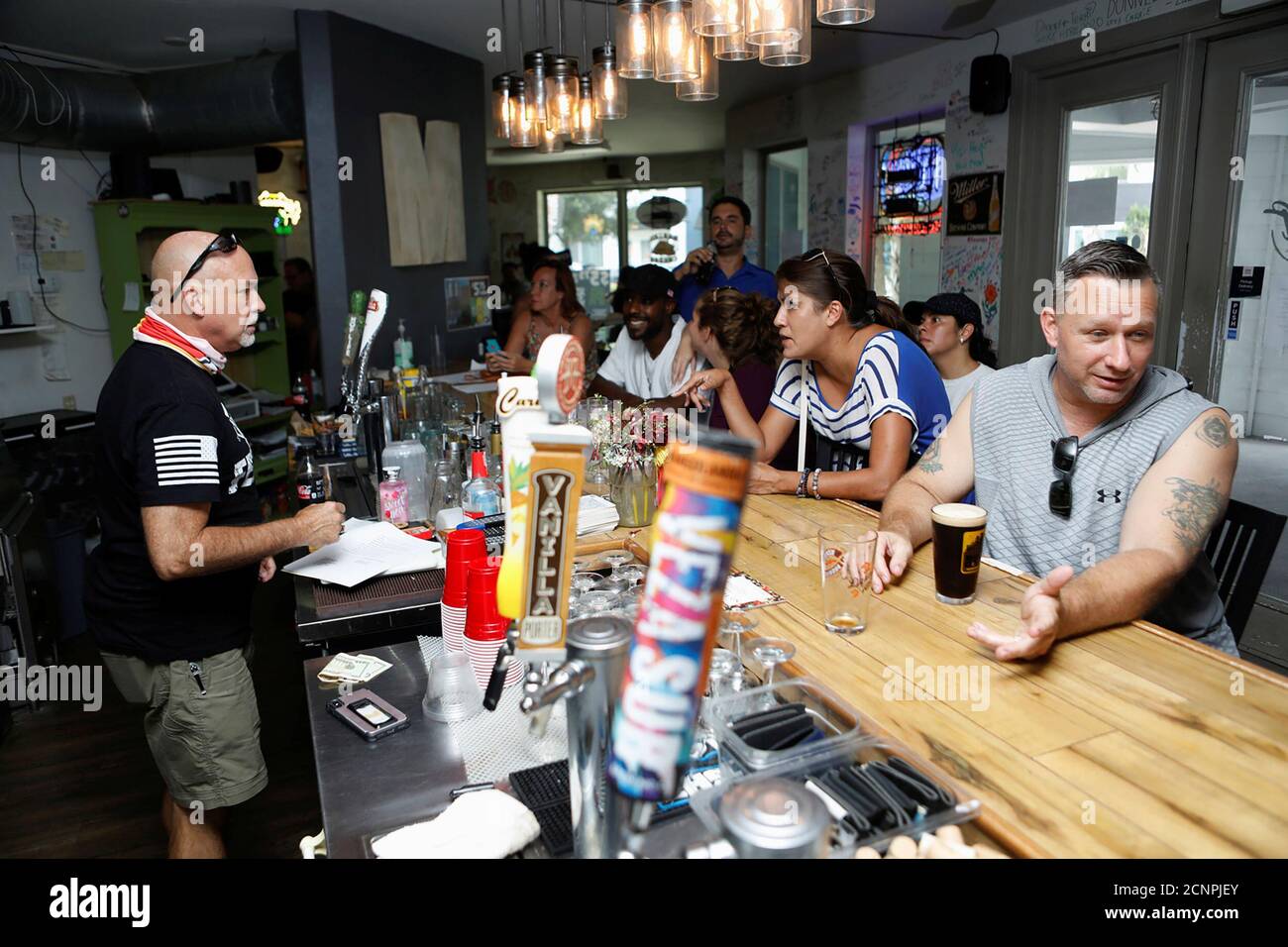 Bar patrons attend the reopen Florida 'maskless' rally and dinner held at 33 & Melt restaurant to protest mandatory face mask restrictions during the coronavirus disease (COVID-19) pandemic in Windermere, Florida, U.S. July 11, 2020. REUTERS/Octavio Jones Stock Photo