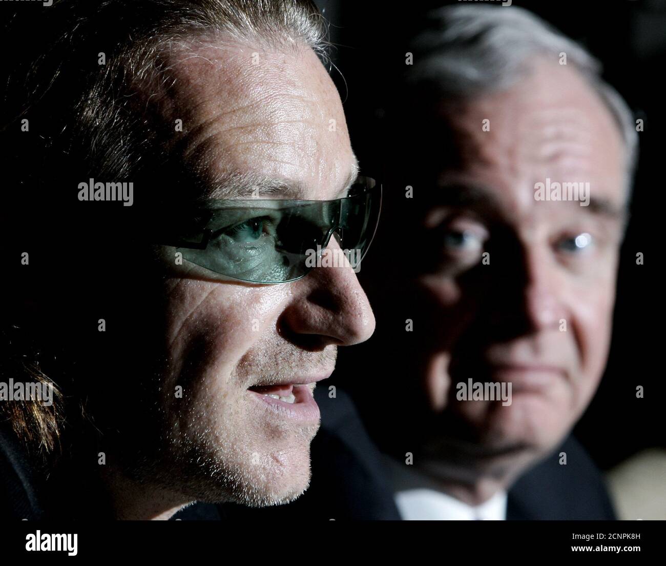 Canadian Prime Minister Paul Martin (R) listens to Bono, lead singer for the band U2, in Ottawa, May 12, 2004. Bono was supporting the government doubling of its support for the international AIDS fund to C$70 million for the 2005-06 fiscal year. REUTERS/Jim Young  JY Stock Photo