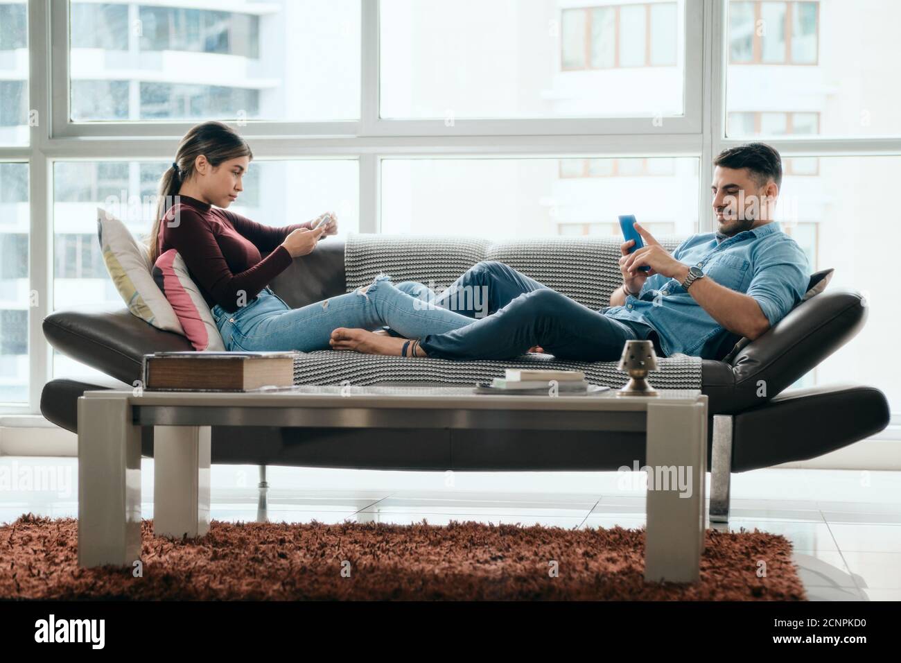 Bored Partners Ignoring Each Other With Mobile Phones Stock Photo
