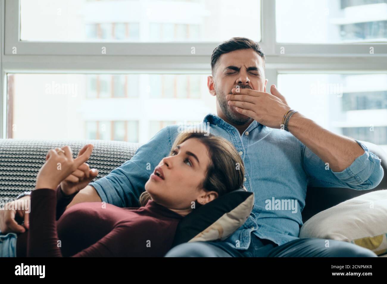 Man Yawning During Boring Conversation With Partner Stock Photo
