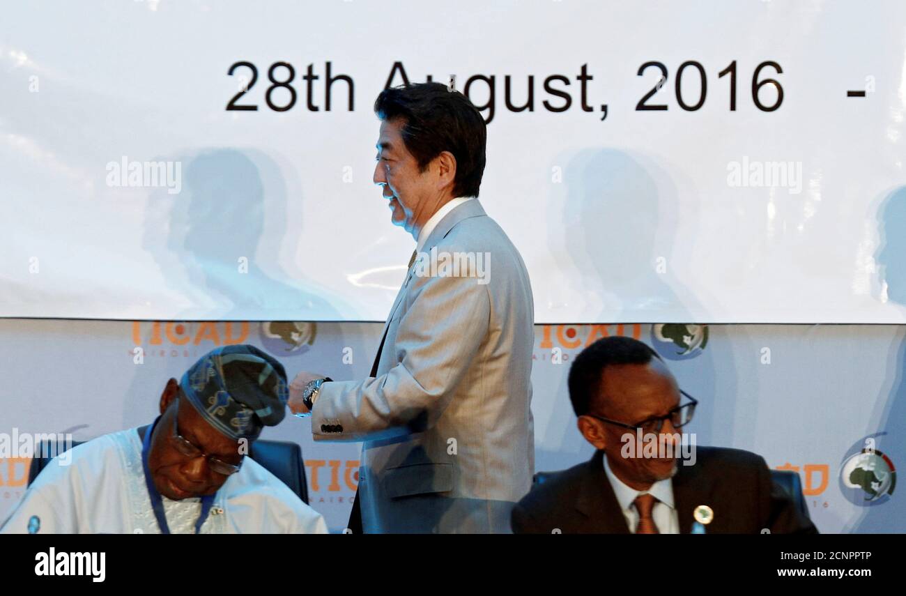 Japan's Prime Minister Shinzo Abe (C) walks past Rwanda's President Paul Kagame (R) and Nigeria's former President Olusegun Obasanjo as he arrives for the Japan International Cooperation Agency (JICA) High Level Panel as part of the Sixth Tokyo International Conference on African Development (TICAD VI) in Kenya's capital Nairobi, August 28, 2016. REUTERS/Thomas Mukoya Stock Photo