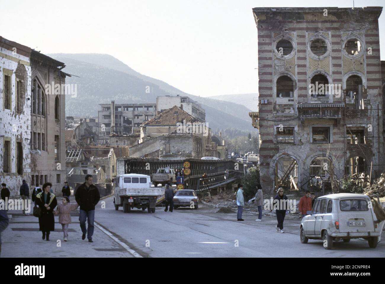 10th December 1995 During the war in Bosnia: the view west, down Mostarskog bataljona on the east (Muslim) side of the river in Mostar, towards a temporary bridge (today, the Most Musala), over the Neretva River. Stock Photo