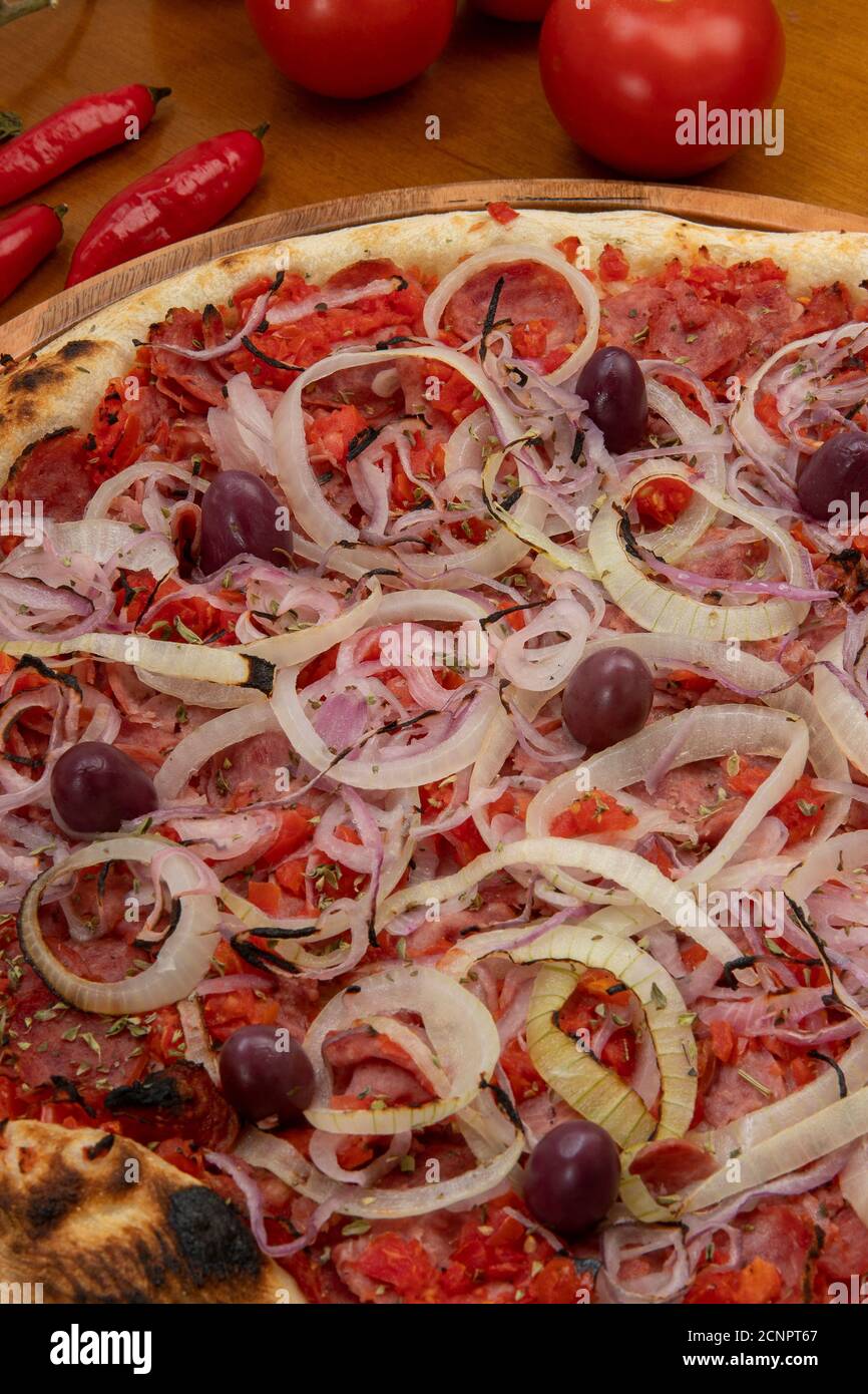 Pizza de Calabresa, Brazilian food. Calabrese sausage pizza with mozzarella cheese, onion and tomato sauce. Traditional pizza in Brazil, it is similar Stock Photo