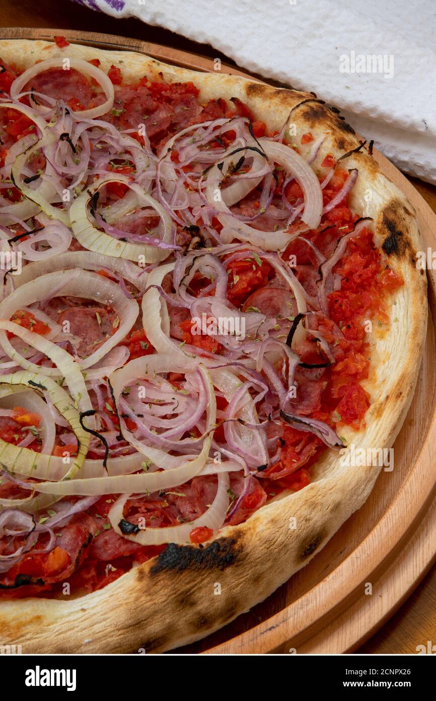 Pizza de Calabresa, Brazilian food. Calabrese sausage pizza with mozzarella cheese, onion and tomato sauce. Traditional pizza in Brazil, it is similar Stock Photo