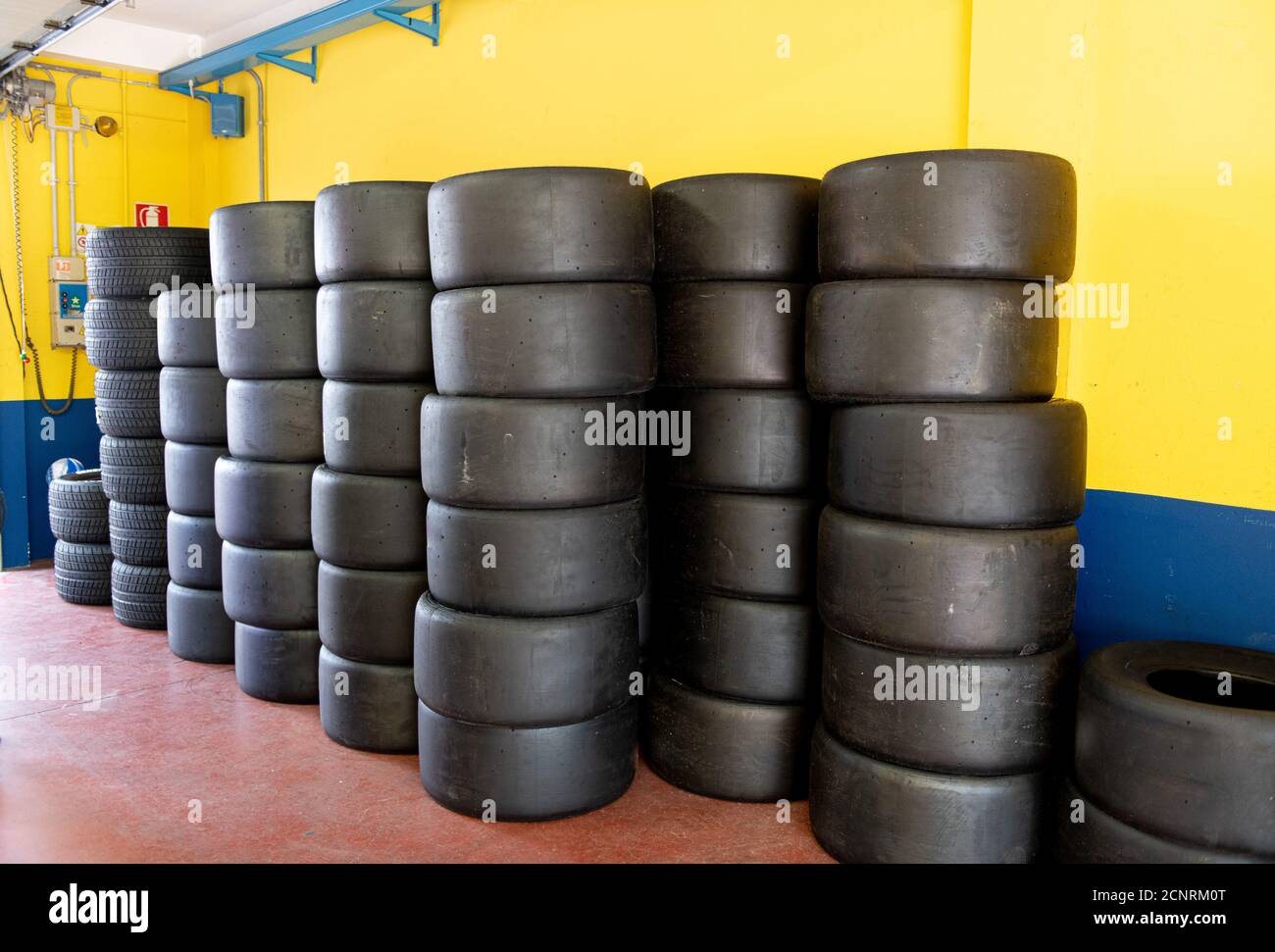 Large group of racing car slick tyres piles in circuit box paddock Stock Photo