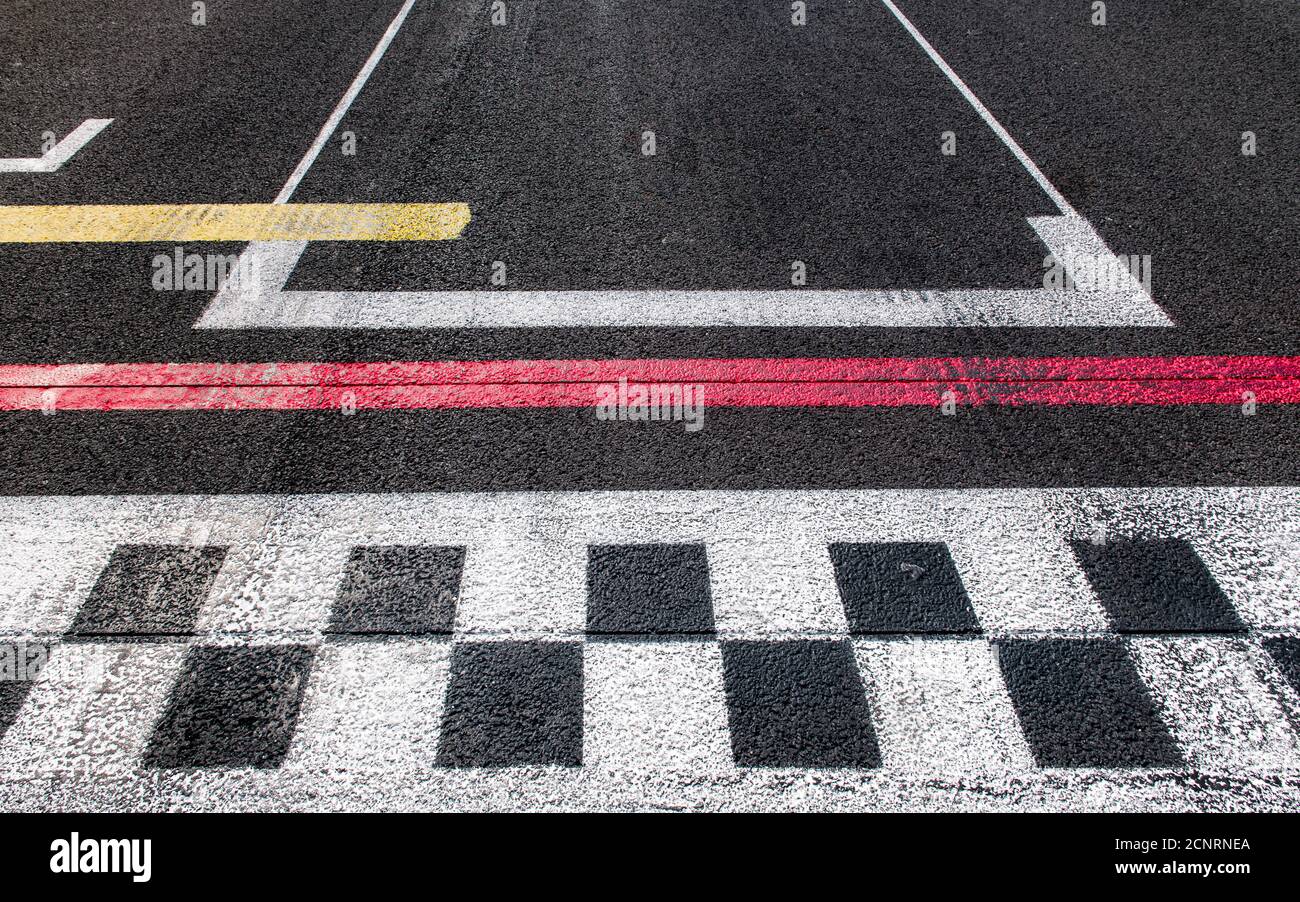 Concept of finish, top, winner, goal, motorsport checked finish line close up on rough asphalt track Stock Photo