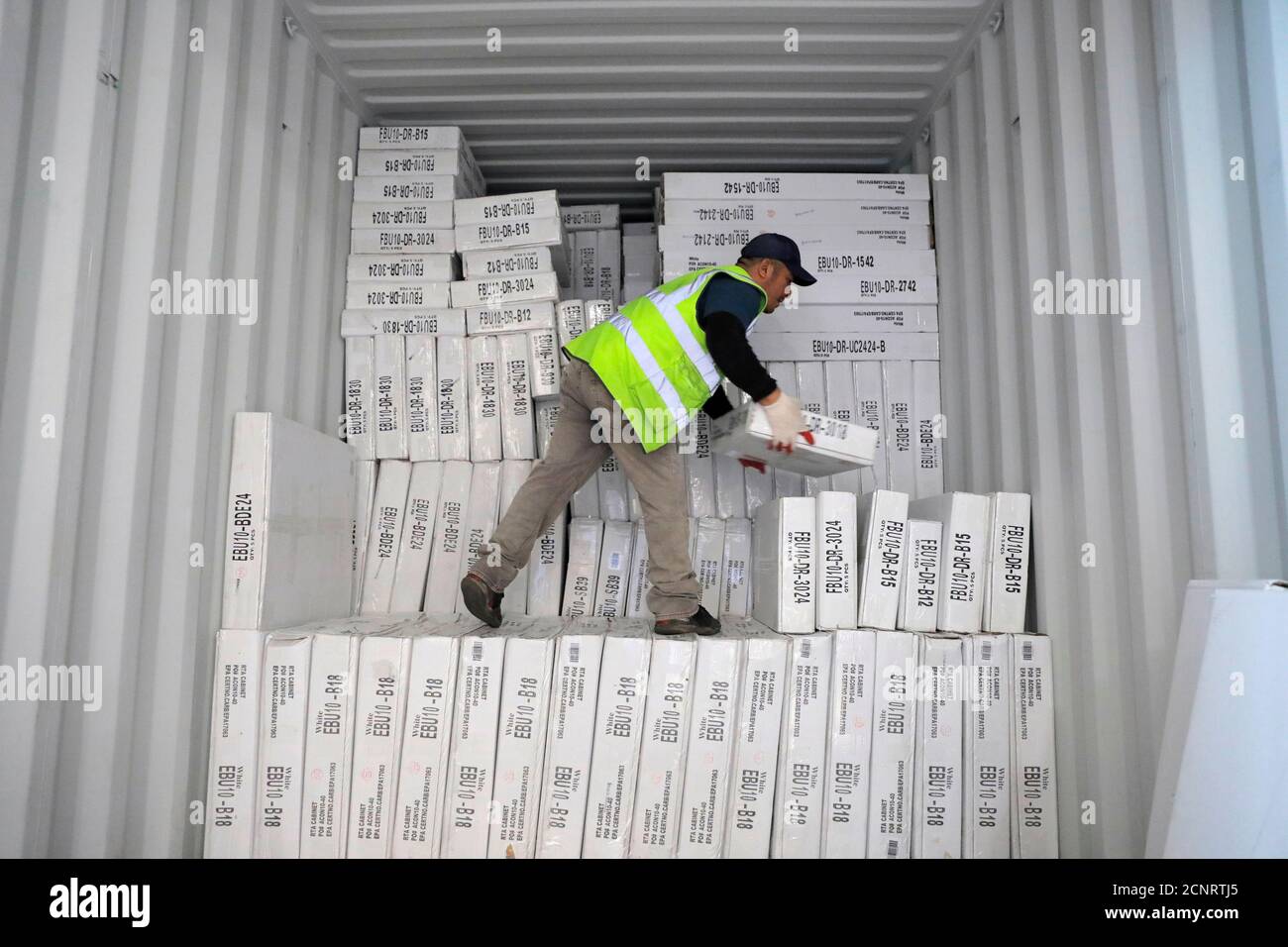 A worker unloads a delivery from Indonesia at CNC Cabinetry in South Plainfield, New Jersey, U.S., June 16, 2020. REUTERS/Andrew Kelly Stock Photo