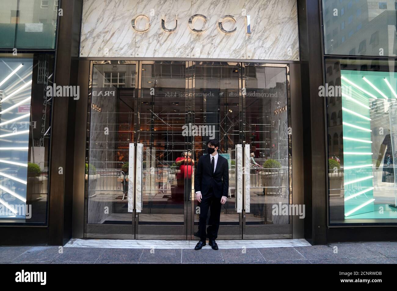 An employee stands outside a Gucci store on the first day of the phase two  re-opening of businesses following the outbreak of the coronavirus disease  (COVID-19), in the Manhattan borough of New