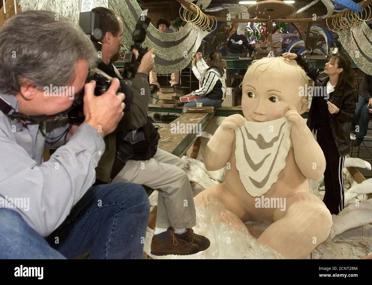 Soap opera actress Nancy Lee Grahn from the series 'General Hospital' works a baby character on the Ivory Soap float December 28, 2001 in Pasadena as photographers take pictues perched on scaffolding. The float featues a classic bath time scene based on Ivory soap advertising from the early 1900's. The float will be featured in the Tournament of Roses parade on New Year's Day 2002 in Pasadena. REUTERS/Fred Prouser  FSP Stock Photo