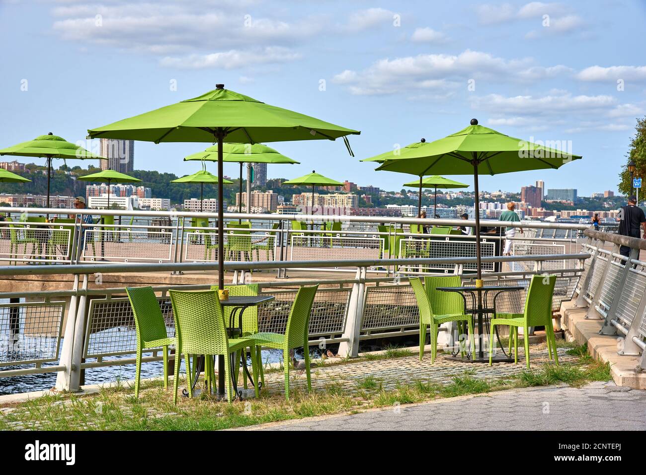 The iconic green umbrellas and chairs of the Pier i Cafe in Riverside Park on the Upper West Side of Manhattan, New York City Stock Photo