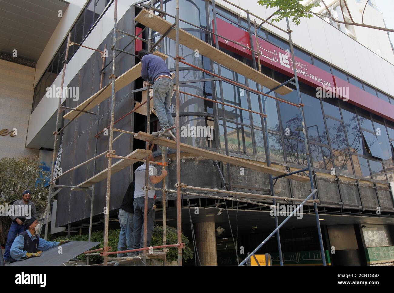 Workers board up the facade of a branch of Banque Libano Francaise (BLF), as a protection measure amid protests against growing economic hardship, in Beirut, Lebanon April 30, 2020. REUTERS/Mohamed Azakir Stock Photo