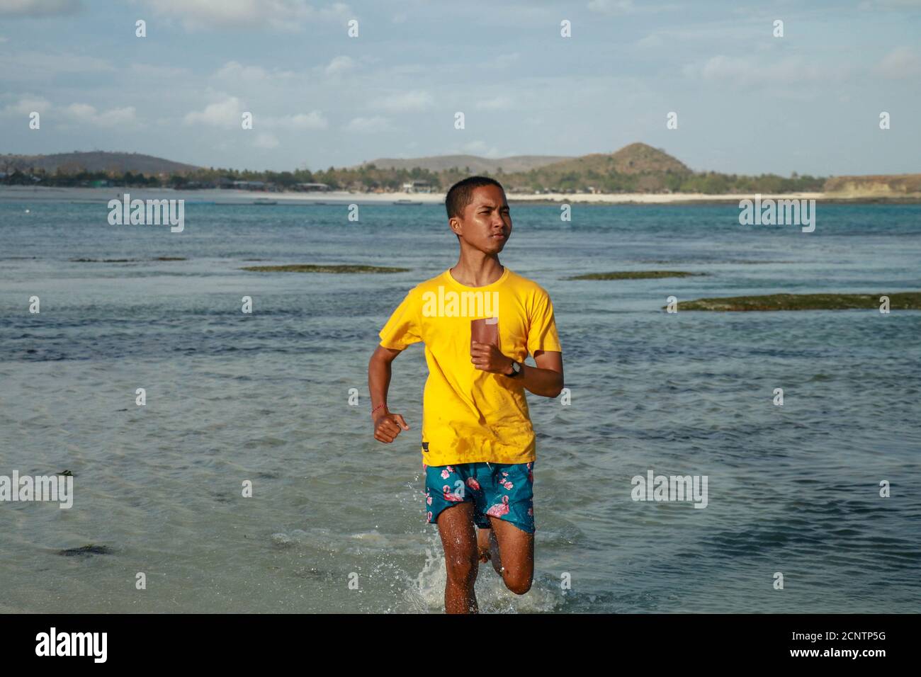 Young man running on beach asian hi-res stock photography and images ...
