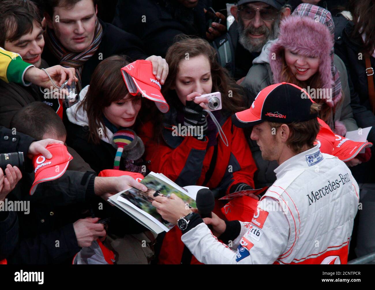 McLaren Formula One racing driver Jenson Button of Britain signs autographs before the unveiling of the F1 McLaren Mercedes MP4-26 racing car in Berlin, February 4, 2011.  REUTERS/Thomas Peter  (GERMANY - Tags: SPORT MOTOR RACING) Stock Photo