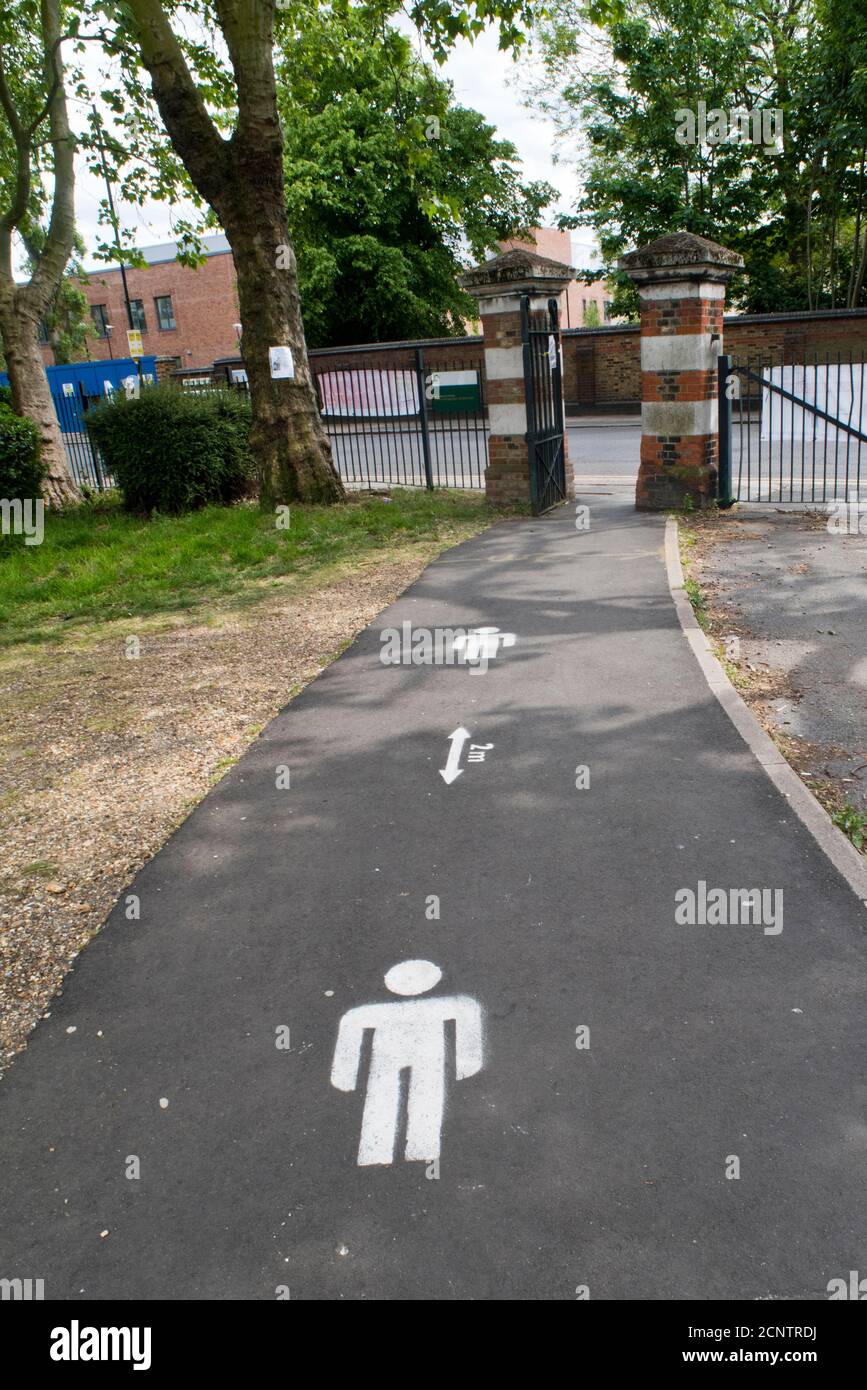 Sign painted on the ground in a London park indicating the two-metre rule that people had to obey during the Covid-19 pandemic in 2020. Stock Photo