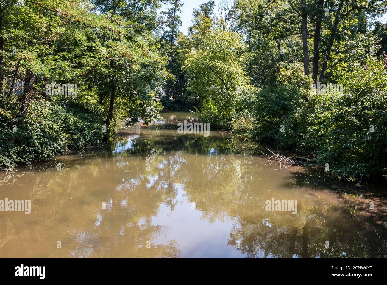 River with brown water along the countryside Stock Photo
