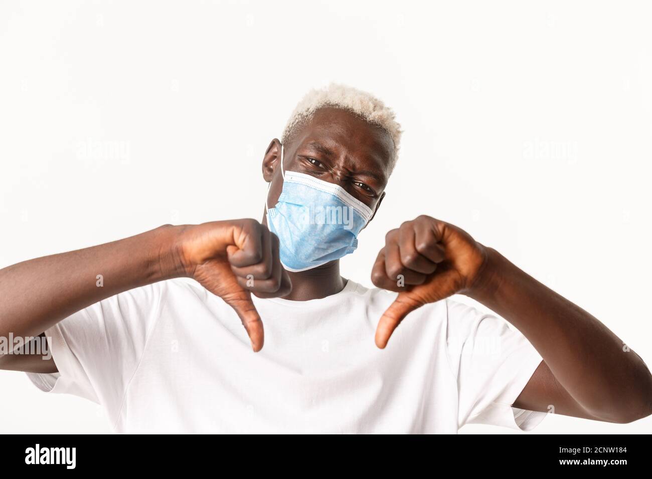 Close-up of disappointed Black man with blond hair, wearing medical ...