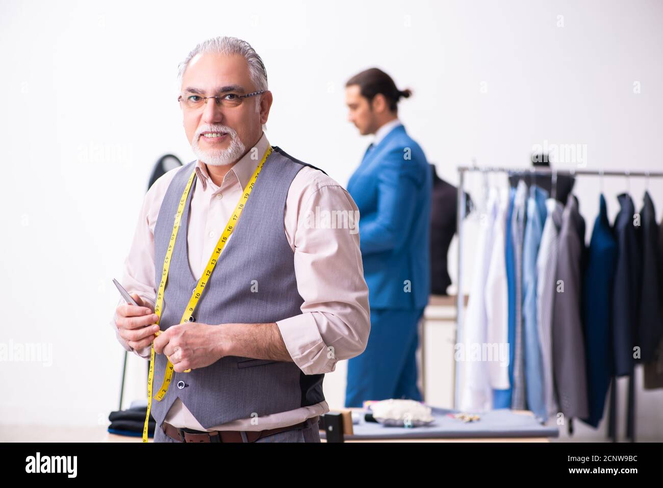 Young businessman visiting old tailor Stock Photo