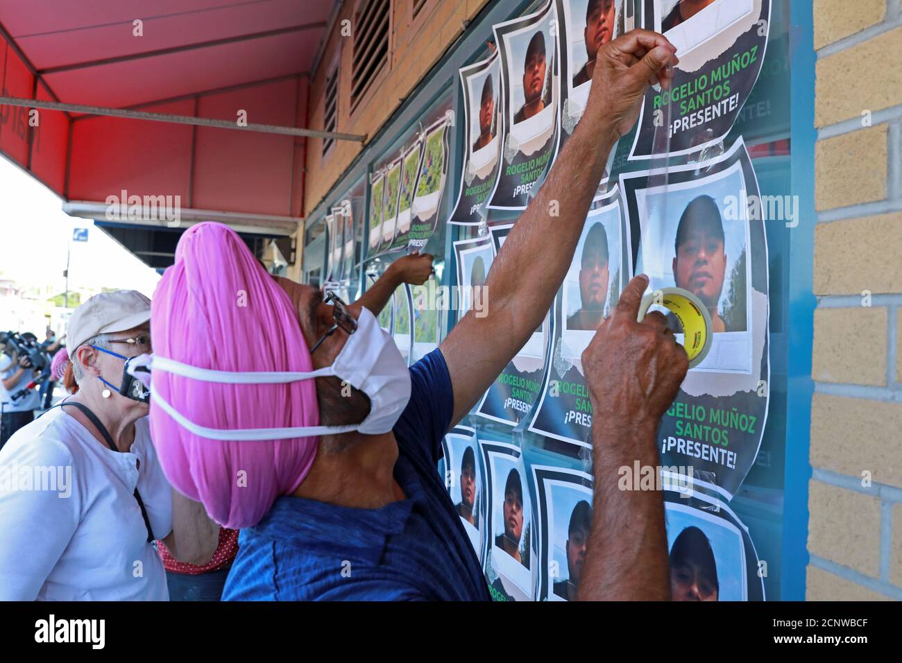 Supporters tape photographs of migrant worker Rogelio Munoz Santos, who  died from coronavirus disease (COVID-19), during a pro-immigration rally by  migrants, refugees and undocumented workers outside the office of Canada's  Immigration Minister