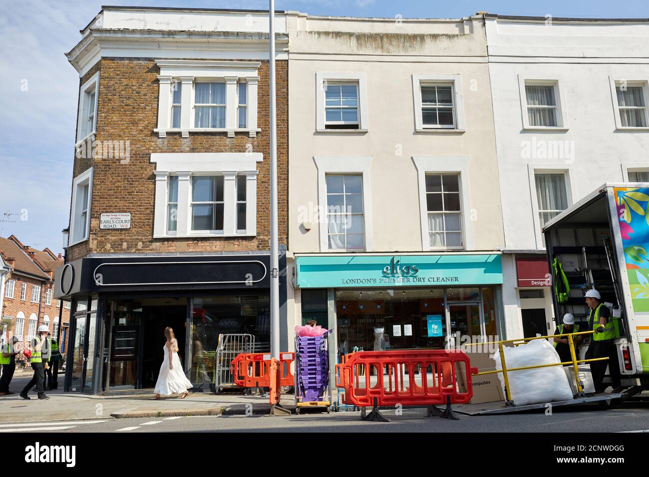 London, UK. - 16 Sept 2020: A woman stares into the Pizza Express on Earl's Court Road as workmen remove the contents. The Kensington restaurant is one of 73 the company has shut due to a downturn caused by the coronavirus pandemic. Stock Photo