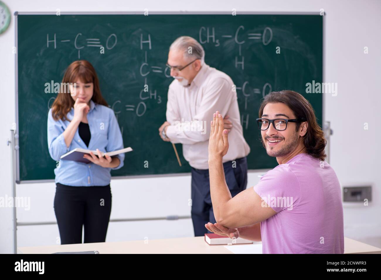 Old teacher and two students in the classroom Stock Photo - Alamy