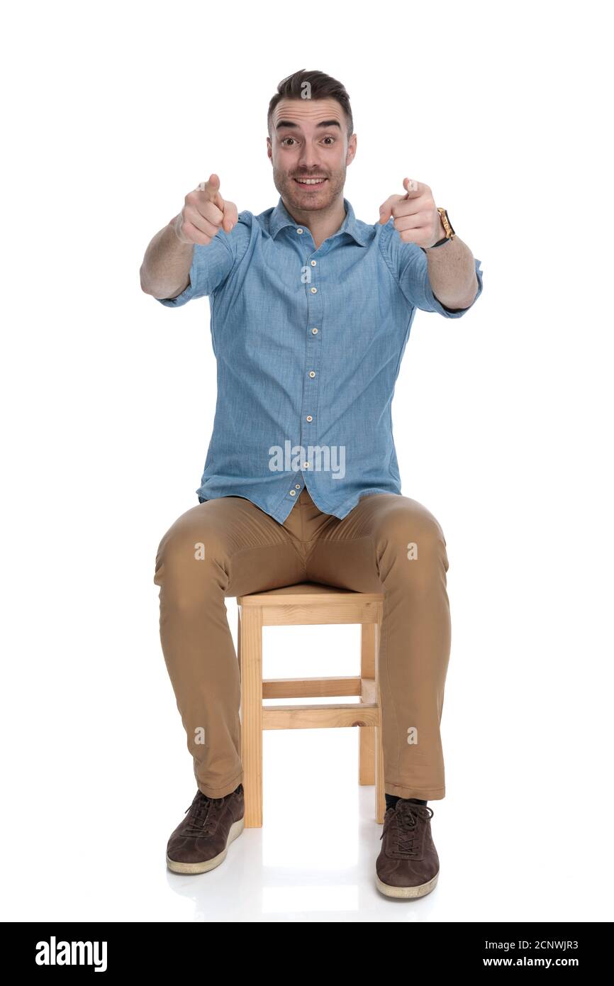 Cheerful smart casual man pointing forward with both hands while ...