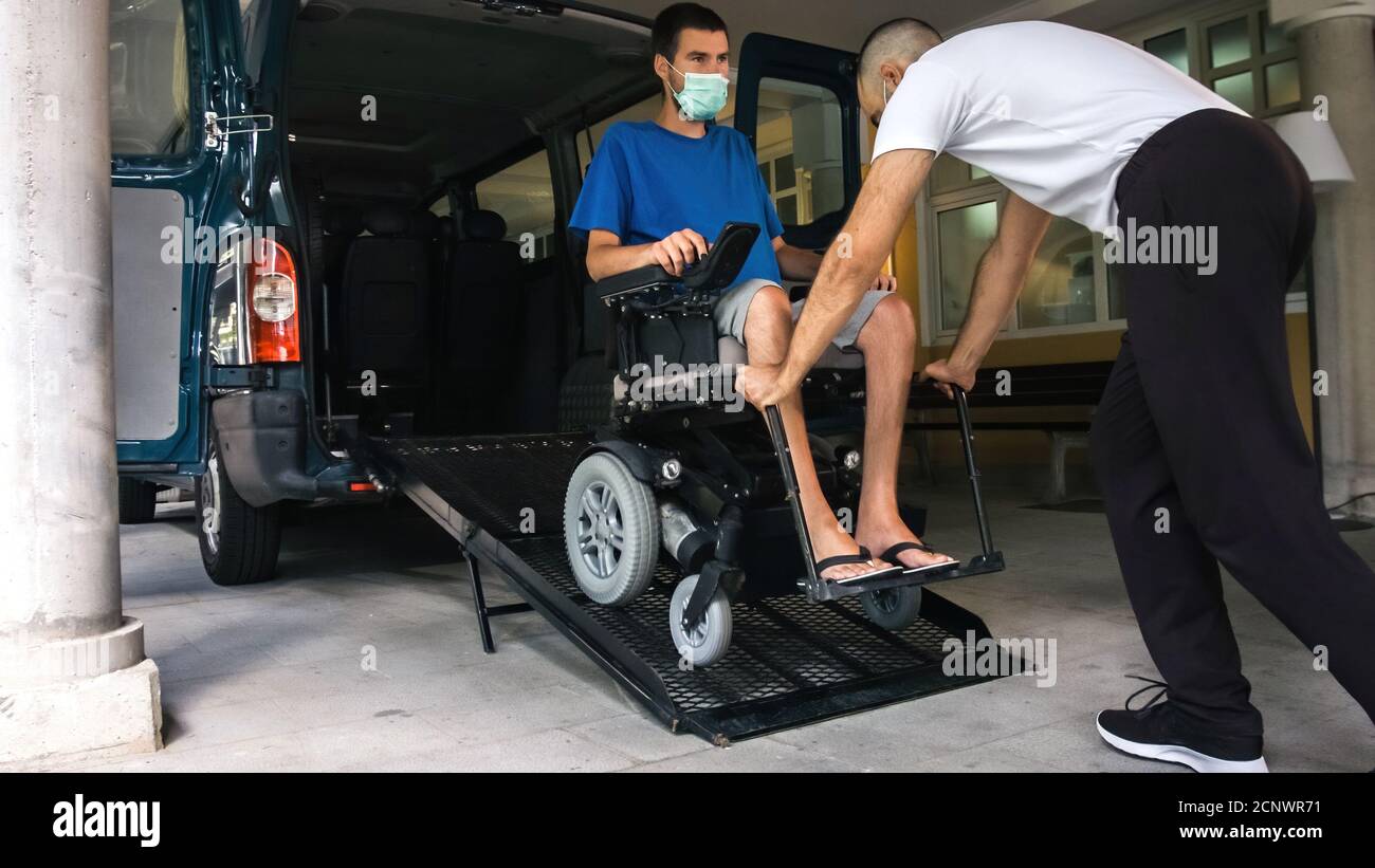 Man on wheelchair using accessible vehicle with ramp for transportation ...