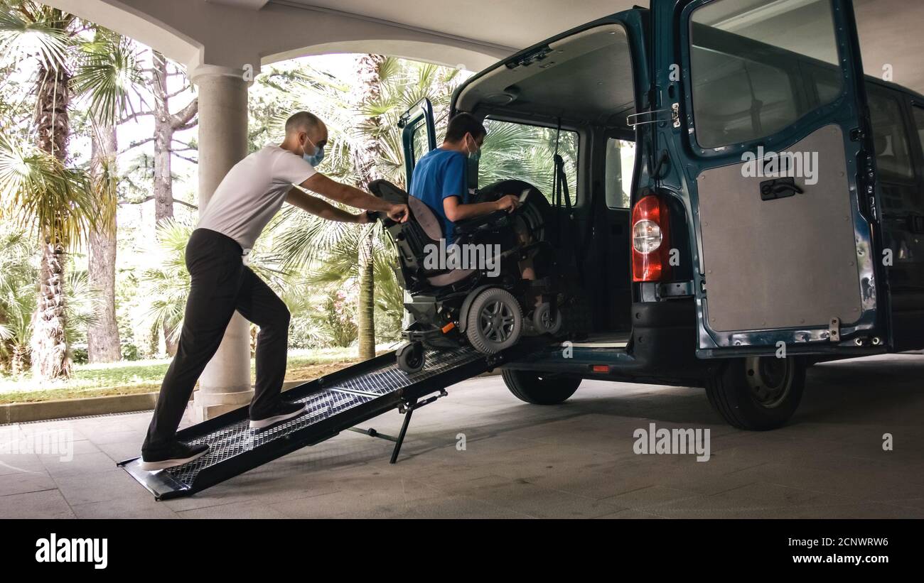 Man on wheelchair using accessible vehicle with ramp for transportation