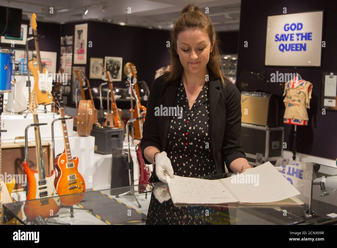 London, UK. 28 June 2016. A Bonhams employee looks through Freddie Mercury's studio lyric book, used while recording The Miracle and Innuendo, est. GBP 50,000-70,000. Bonhams presents lots from the forthcoming Entertainment Memorabilia sale taking place on 29 June. Stock Photo