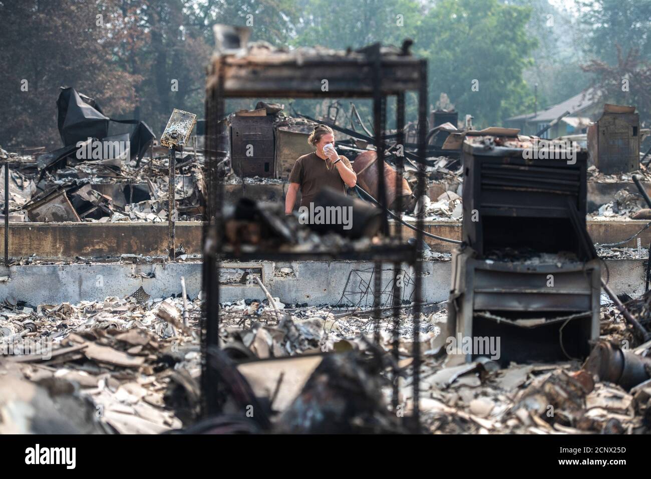 Talent, United States. 18th Sep, 2020. TALENT, ORE - SEPTEMBER 18, 2020: Zach Kuhlow checks the remnants of his house for anything salvagable. His son, who is now 10, was born inside the house. In Talent, about 20 miles north of the California border, homes were charred beyond recognition. Across the western US, at least 87 wildfires are burning, according to the National Interagency Fire Center. They've torched more than 4.7 million acres -- more than six times the area of Rhode Island. Credit: Chris Tuite/imageSPACE Credit: Imagespace/Alamy Live News Stock Photo