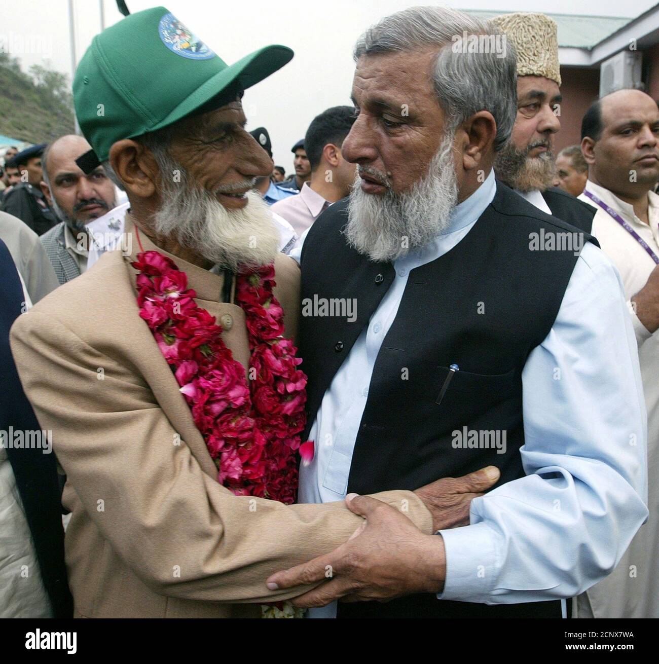 An Indian Kashmiri is hugged by his Pakistani relative upon arrival at the Pakistani border near the 'Peace Bridge' in Chakothi.  An Indian Kashmiri (R) is hugged by his Pakistani relative upon arrival at the Pakistani border near the 'Peace Bridge' in Chakothi, on the Line of Control, about 58km (36 miles) south of Muzaffarabad in Kashmir April 7, 2005. Showered with tears and rose petals from relatives thought lost, two groups of Indian and Pakistani Kashmiris walked over the 'Peace Bridge' on Thursday, breaking through a military line that has divided them and their land with blood for almo Stock Photo
