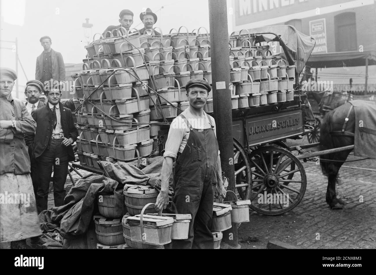 Men standing around a cart filled with baskets of peaches at South Water Street Market, Chicago, Illinois, circa 1902. Stock Photo