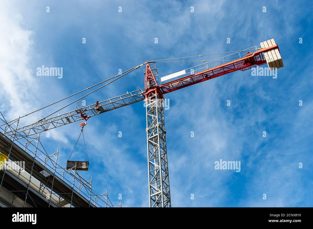 Red tower crane building against a blue sky Stock Photo