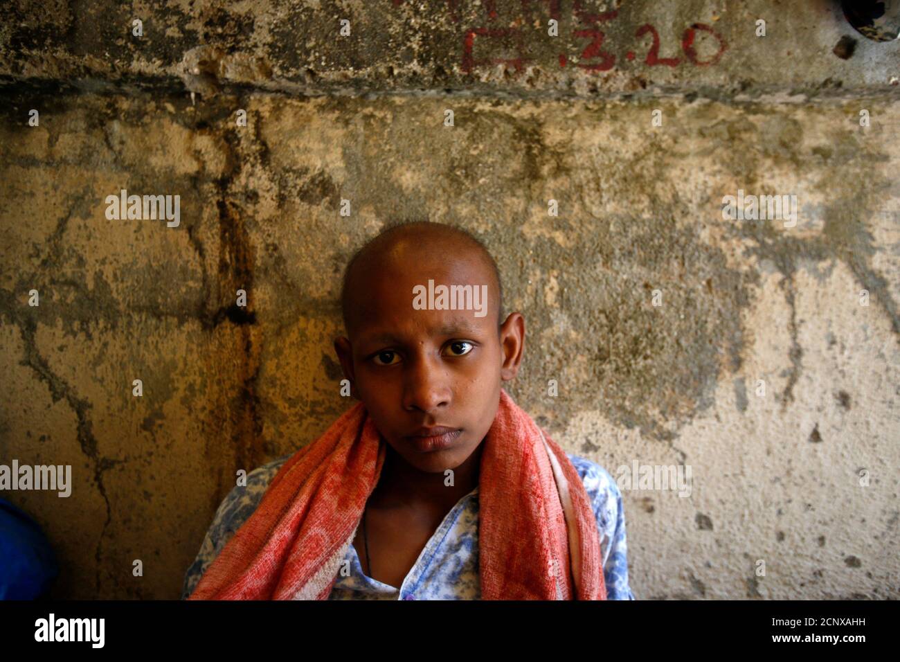 Cancer patient Raj Kishore Kumar, 12, sits inside a makeshift shelter on a pavement outside the Tata Memorial Hospital in Mumbai April 2, 2013.  India's top court dismissed Swiss drugmaker Novartis AG's attempt to win patent protection for its cancer drug Glivec, a blow to Western pharmaceutical firms targeting India to drive sales and a victory for local makers of cheap generics. REUTERS/Vivek Prakash (INDIA - Tags: BUSINESS DRUGS SOCIETY HEALTH) Stock Photo