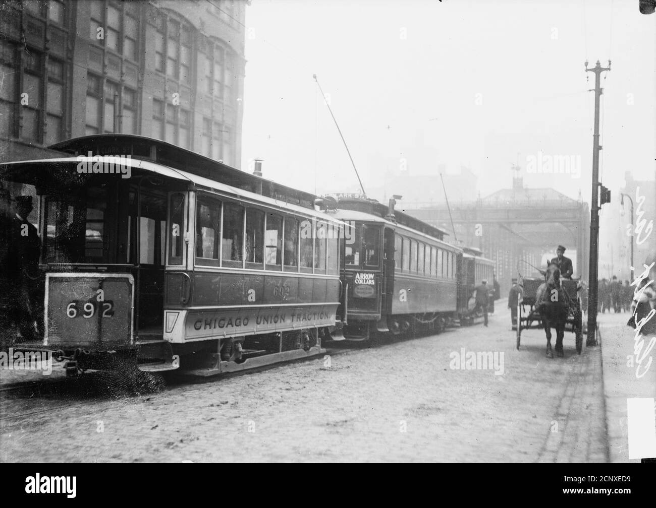Three electric trolley cars lined up on North Clark Street with a horse