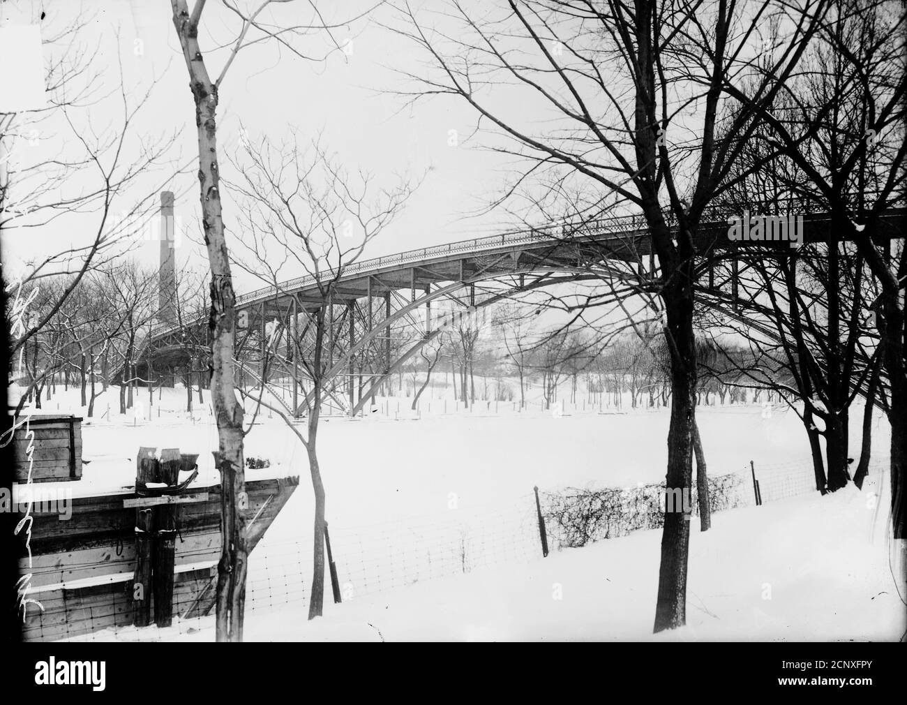 Light exposure view of a pedestrian bridge, known as High Bridge, over Lincoln Park in Chicago, Illinois, with the ground covered in snow. Stock Photo