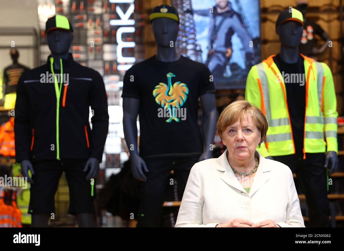 German Chancellor Angela Merkel stands in front of models wearing the  clothing of German workwear manufacturer