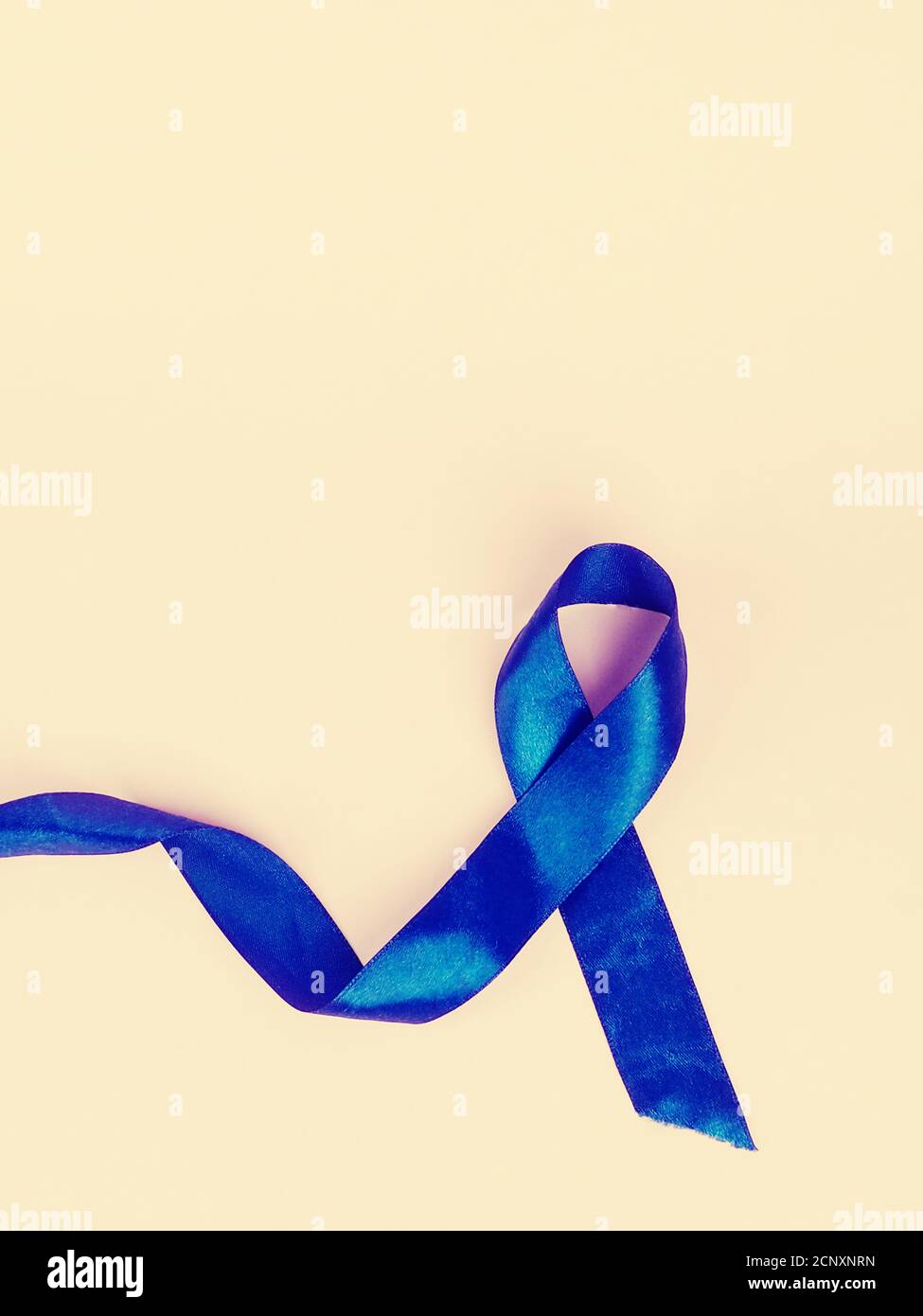 Awareness blue ribbon isolated on pink background for prostate cancer awareness campaign and men's health concept Stock Photo
