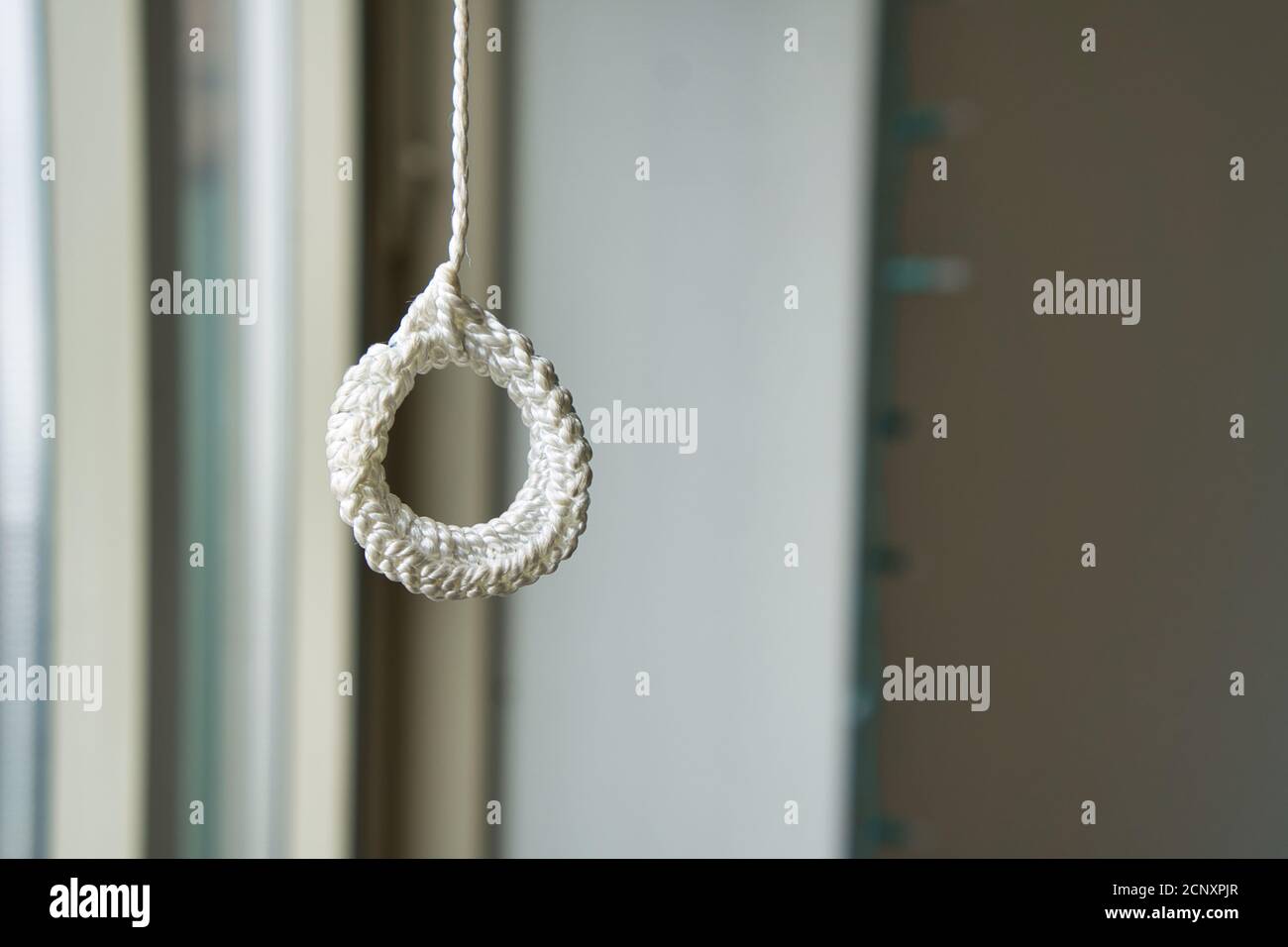 white rope loop hanging against blurry background Stock Photo - Alamy
